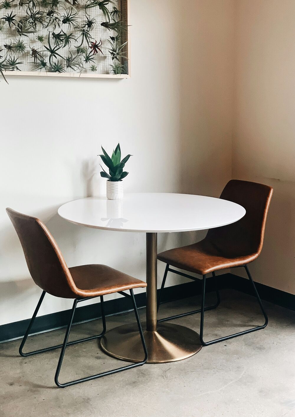 Coin repas avec table ronde blanche et chaises en cuir